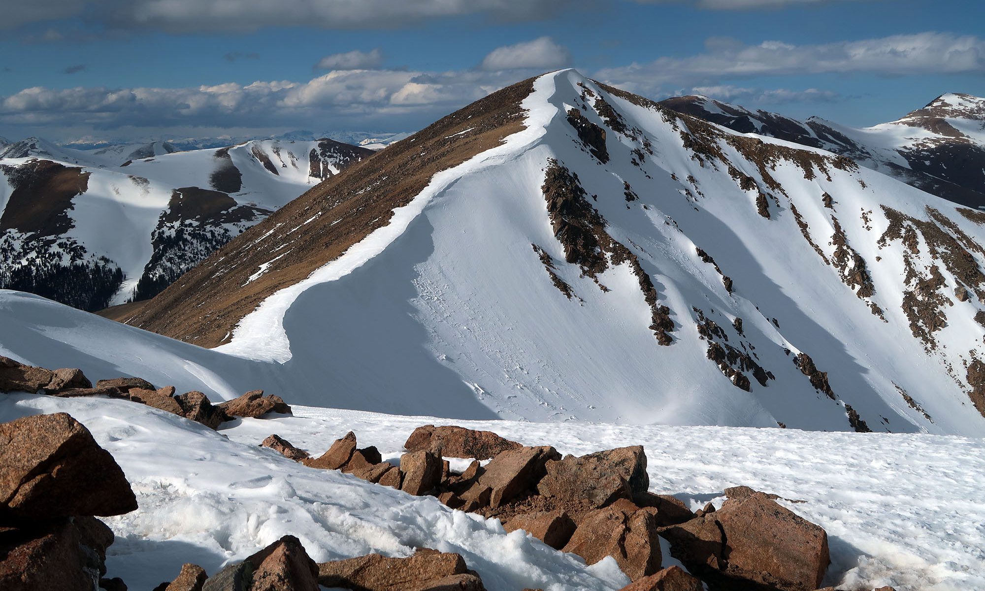 Low, afternoon sunlight accentuates a melting cornice along Mount Sniktau's summit ridge.