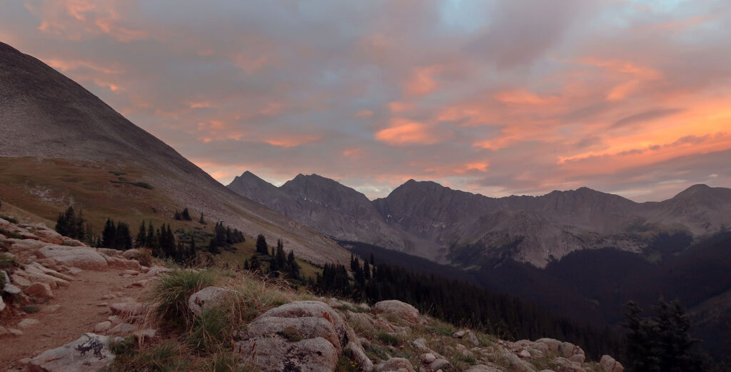Sunrise lights up the clouds over the "Three Apostles" en route to Huron Peak.