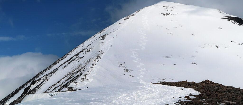 Hikers ascend the ridge next to Quandary Bowl, a relatively low-angle descent of the upper mountain.