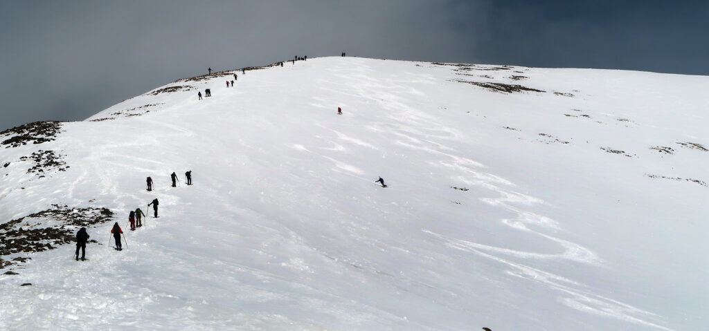 A skier/boarder pair descends the upper bowl.