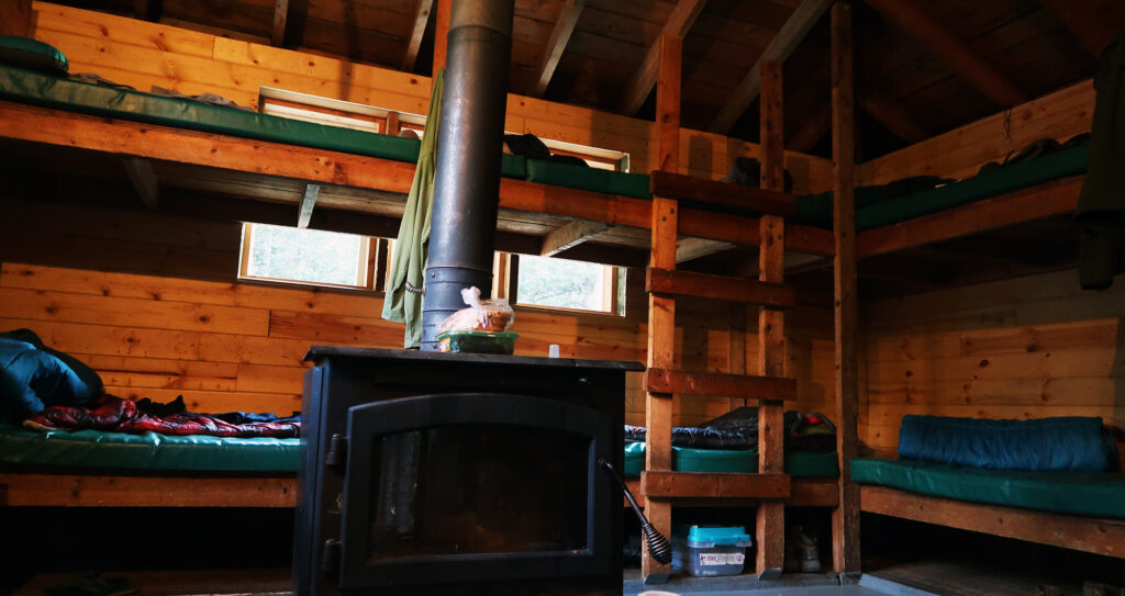 Bunks and a wood stove inside one of the huts.