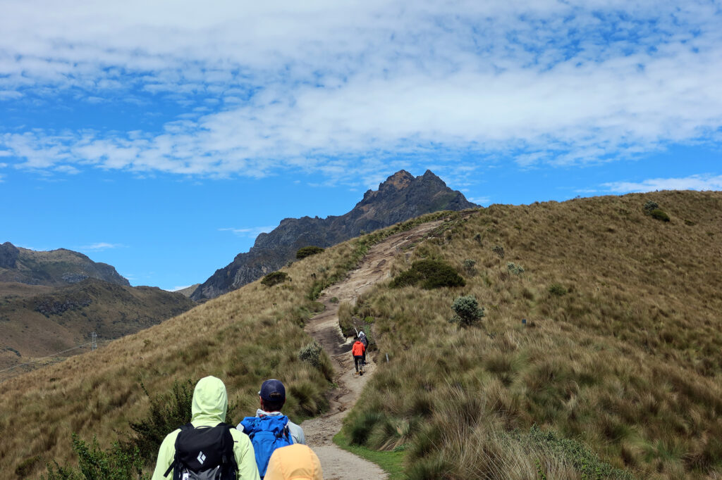 Hiking the lower, grassy slopes, with Ruku Pichincha in the background.