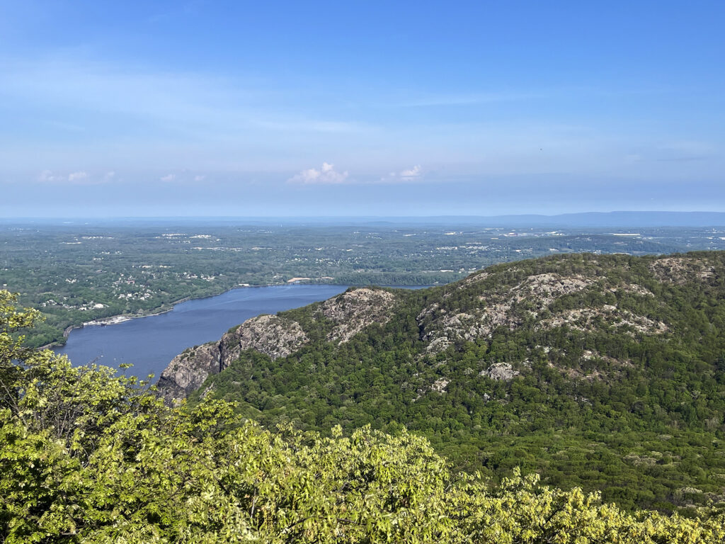 Breakneck Ridge to the North, with the Hudson River, Newburgh, and the distant Catskills visible beyond and to the right.
